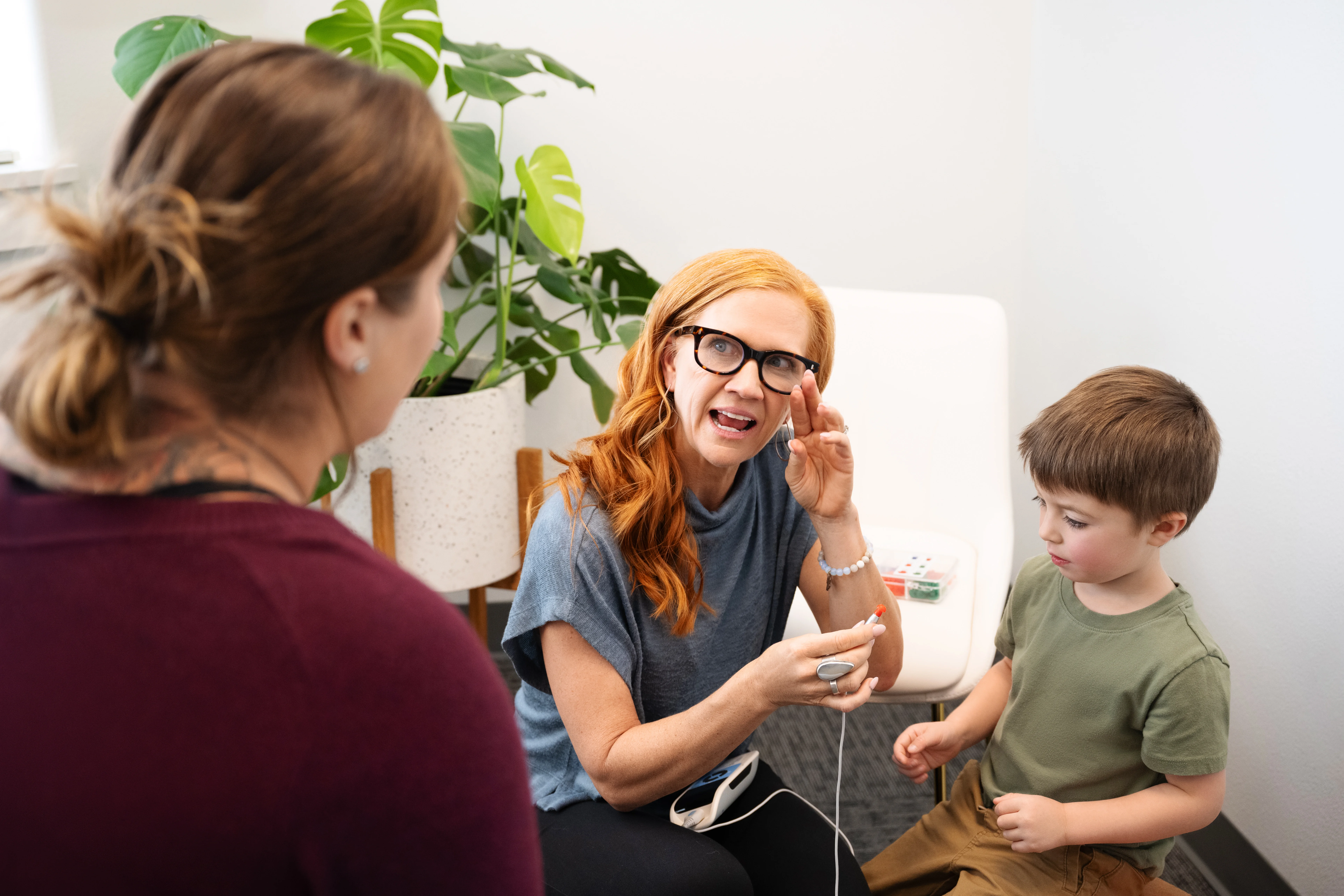 kelly explaining hearing test to mom and son
