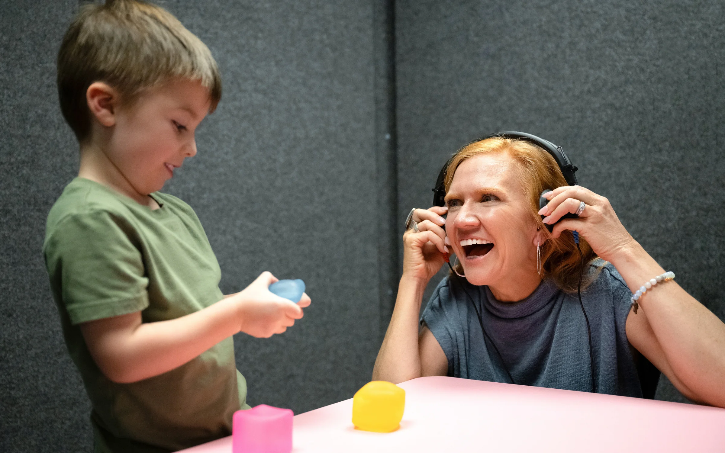 boy playing with blocks while kelly tests